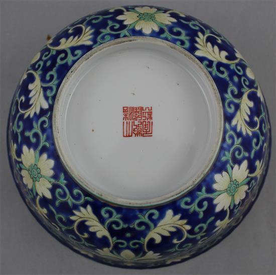 A Chinese blue ground porcelain bowl, Qianlong mark, late 19th / early 20th century, 21.5cm diam., wood stand